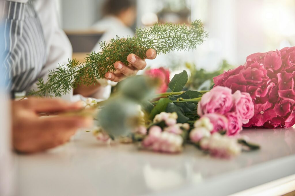 Skilled hands of a florist holding a delicate plant