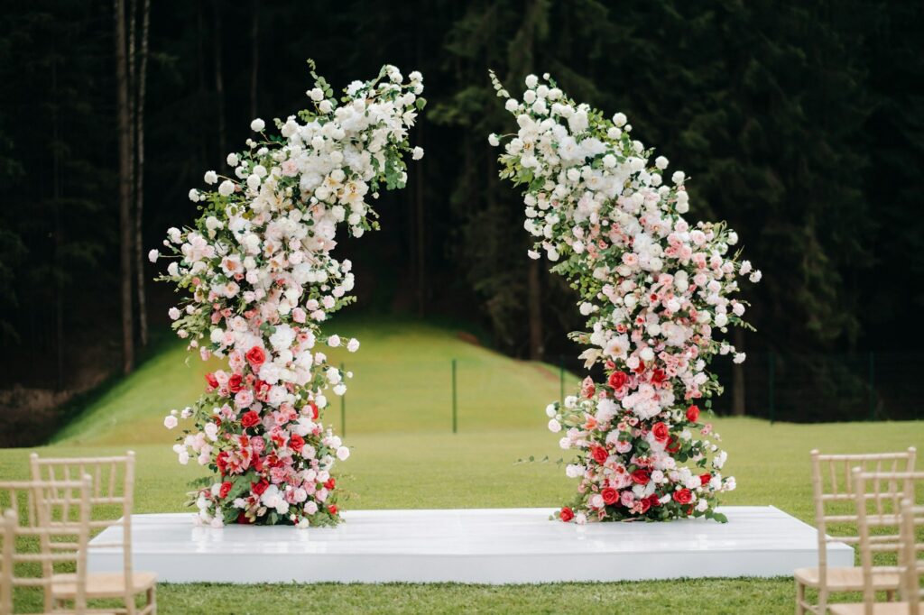 Wedding ceremony on the street on the green lawn.Decor with fresh flowers arches for the ceremony